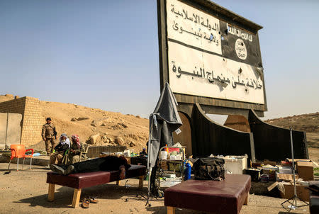 A displaced woman lies down at a field hospital beneath a billboard erected by Islamic state's militants as battle continues against Islamic State militants in western Mosul, Iraq, February 28, 2017. The billboard reads, "There is No God Only God. Islamic state Nineveh Governorate". REUTERS/Zohra Bensemra 