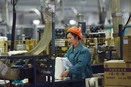 A woman works on a production line manufacturing paper tableware at a factory in Hangzhou, Zhejiang province, China January 21, 2019. REUTERS/Stringer