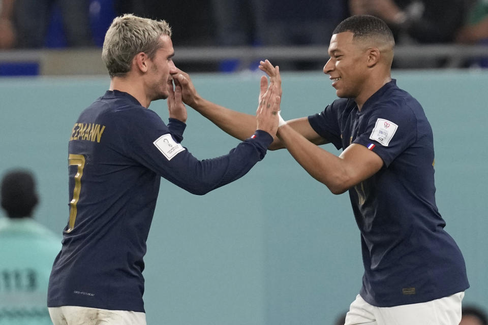 France's Kylian Mbappe, right, celebrates with France's Antoine Griezmann after scoring his sides first goal during the World Cup group D soccer match between France and Denmark, at the Stadium 974 in Doha, Qatar, Saturday, Nov. 26, 2022. (AP Photo/Thanassis Stavrakis)