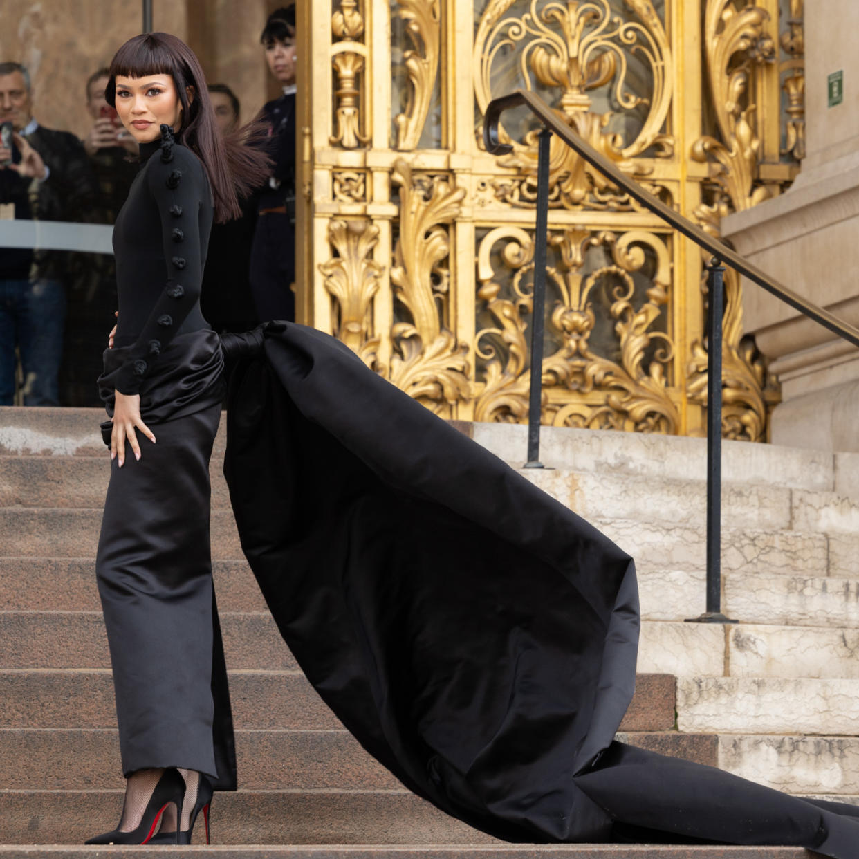  Zendaya wearing a long sleeve black dress with a long train to Schiaparelli Haute Couture show in Paris. 