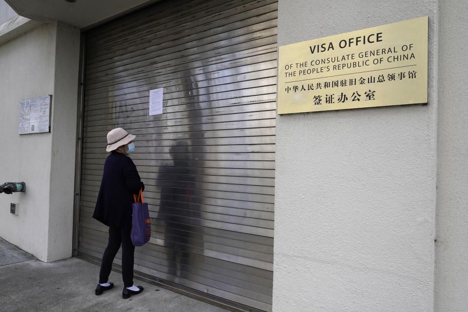 A woman reads a sign that the visa office is temporarily closed at the Chinese consulate in San Francisco Tuesday, Oct. 10, 2023. A car rammed into the consulate in San Francisco on Monday, coming to a stop in the lobby and creating a chaotic scene that ended with police shooting the driver, who later died at the hospital, officials said. (AP Photo/Eric Risberg)