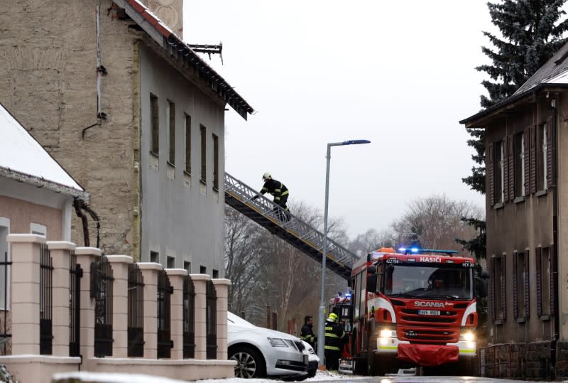 A fire fighter climbs a ladder next to a home for people with disabilities which was affected by a fire, in Vejprty