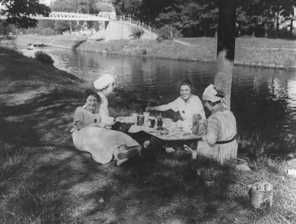 <p>A group of friends lounge in the shade as they enjoy a riverside picnic.</p>