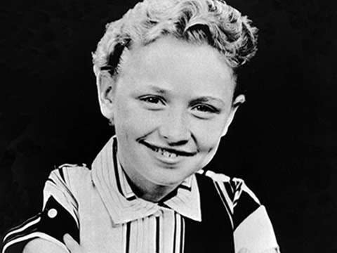 black and white photo of Dolly Parton as a child with short hair