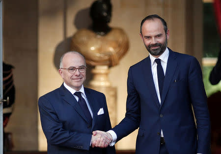 Newly-appointed French Prime Minister Edouard Philippe (R) is greeted by his predecessor Bernard Cazeneuve (L) during a handover ceremony at the Hotel Matignon, in Paris, France, May 15, 2017. REUTERS/Benoit Tessier