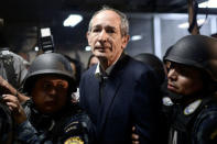 Former Guatemalan President Alvaro Colom arrives to court escorted by policemen after being detained as part of a local corruption investigation, in Guatemala City, Guatemala February 13, 2018. REUTERS/Fabricio Alonzo