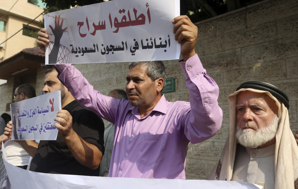 Families of Palestinians held in jails in Saudi Arabia, hold placards in Arabic that read, "Release our sons in Saudi prisons, and No for the policy of isolation and torture for the prisoners in Saudi jails" during a protest, in front of the International Committee of the Red Cross office, in Gaza, Wednesday, Oct. 16, 2019. (AP Photo/Adel Hana)