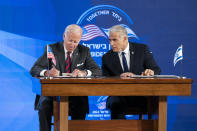 U.S. President Joe Biden and Israeli Prime Minister Yair Lapid sign a joint declaration affirming the "unbreakable bonds" between the two countries and a U.S. commitment to protecting Israeli security, in Jerusalem, Thursday, July 14, 2022. (AP Photo/Evan Vucci)