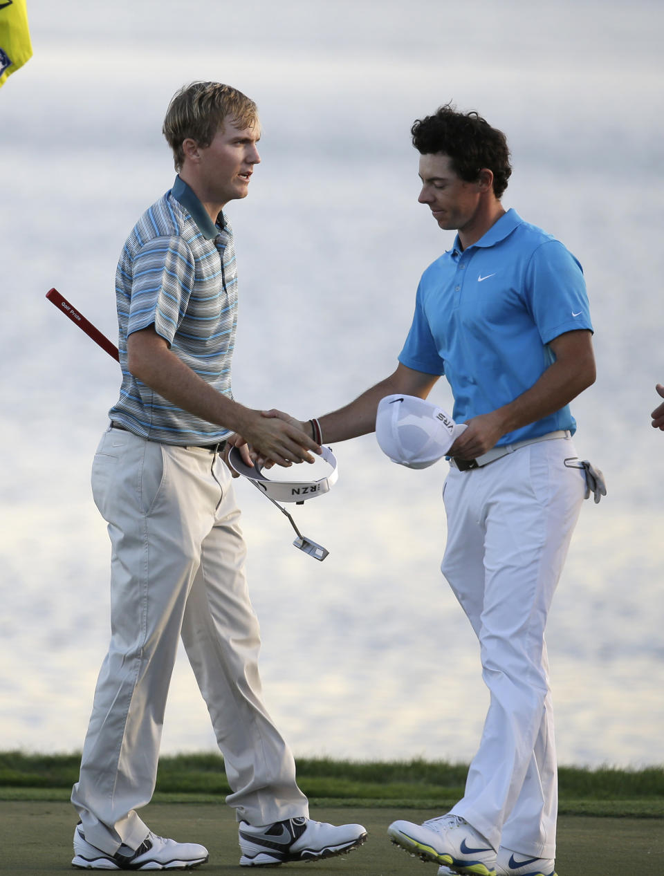 Russell Henley, left, shakes hands with Rory McIlroy, right, of Northern Ireland, after winning on the 18th hole in a four-man playoff in the final round of the Honda Classic golf tournament on Sunday, March 2, 2014, in Palm Beach Gardens, Fla. (AP Photo/Lynne Sladky)