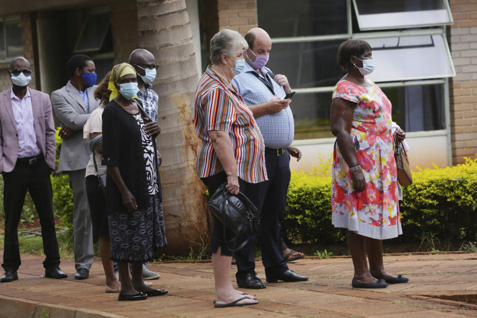 People wait in a queue to get a shot of the sinopharm coronavirus vaccination at Wilkins Hospital in Harare, Wednesday, March, 24, 2021. Zimbabwe is rolling out its COVID-19 inoculation programme and in the first phase is targeting health care workers and the elderly. (AP Photo/Tsvangirayi Mukwazhi)