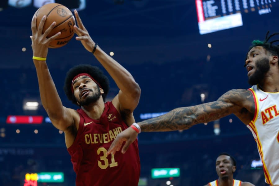 Cleveland Cavaliers center Jarrett Allen (31) grabs a rebound next to Atlanta Hawks forward Saddiq Bey during the first half of an NBA basketball game Saturday, Dec. 16, 2023, in Cleveland. (AP Photo/Ron Schwane)