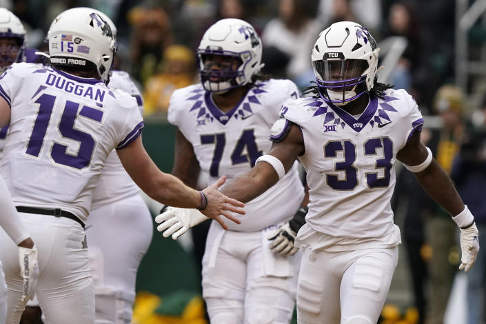 TCU running back Kendre Miller (33) is congratulated quarterback Max Duggan (15) after Miller score a touchdown against Baylor in Waco, Texas, Saturday, Nov. 19, 2022. (AP Photo/LM Otero)