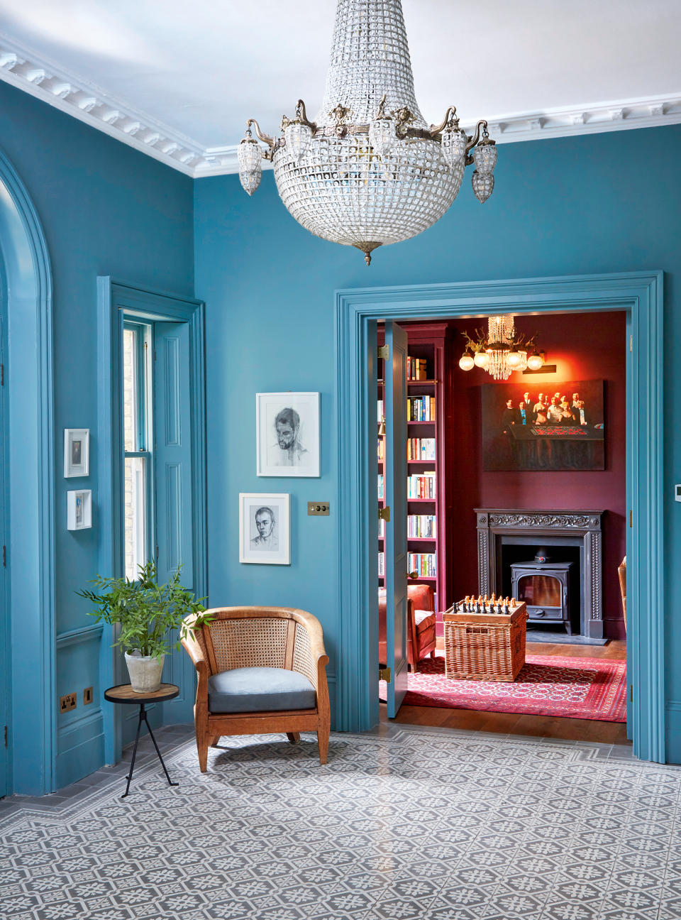 Blue painted hall with patterned floor and chandelier