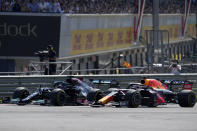 Mercedes driver Lewis Hamilton of Britain, left, and Red Bull driver Max Verstappen of the Netherlands take a curve side-by-side at the start of the British Formula One Grand Prix, at the Silverstone circuit, in Silverstone, England, Sunday, July 18, 2021. (AP Photo/Jon Super)