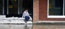 <p>A boy sit on sand bag’s along Second St in Aurora, Indiana on Sunday, Feb. 25, 2018. (Photo: Ernest Coleman via ZUMA Wire) </p>