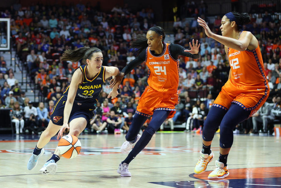 UNCASVILLE, CT - SEPTEMBER 22: Indiana Fever guard Caitlin Clark (22) drives to the basket against Connecticut Sun forward DeWanna Bonner (24) and Connecticut Sun forward Brionna Jones (42) during Round 1 and Game 1 of the 2024 WNBA Playoffs between the Indiana Fever and Connecticut Sun on September 22, 2024 at Mohegan Sun Arena in Uncasville, CT. (Photo by M. Anthony Nesmith/Icon Sportswire via Getty Images)