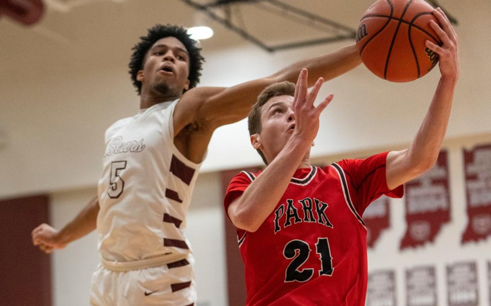 Hudson Horvath (21) of Park Tudor High School  works against Jacob Franklin (5) of Lawrence Central High School  on Wednesday, Jan. 4, 2023, during a game won by Lawrence Central 72-67, at LCHS. 