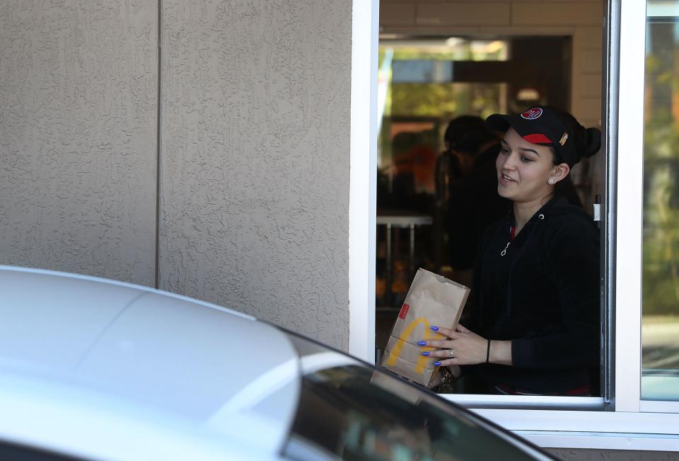 La empleada de McDonald’s Tatiana Cordoso trabaja en la ventanilla de autoservicio en el restaurante McDonald’s, el 25 de abril de 2017 en Miami, Florida. (Foto de Joe Raedle/Getty Images)
