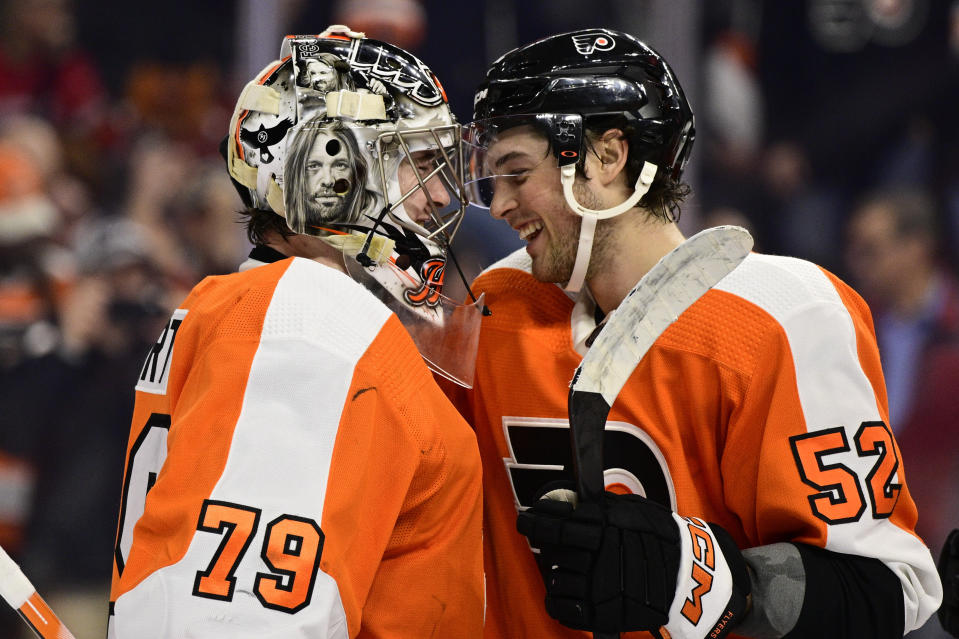 Philadelphia Flyers goaltender Carter Hart (79) and Tyson Foerster (52) celebrate their team's victory after an NHL hockey game against the Detroit Red Wings, Saturday, March 25, 2023, in Philadelphia. (AP Photo/Derik Hamilton)