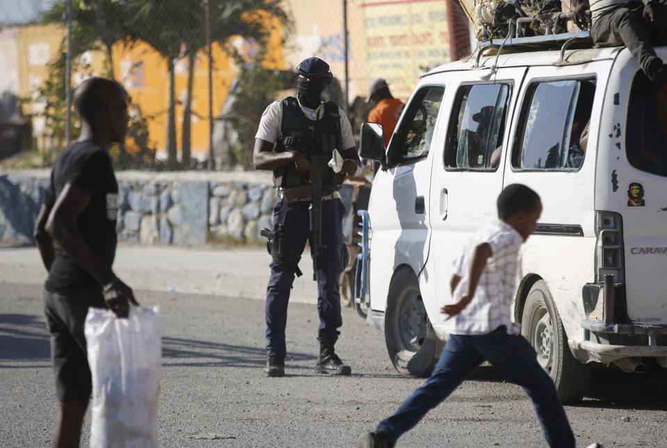 Un agente de la policía inspecciona un vehículo de transporte público en un puesto de control en Puerto Príncipe, Haití, el 26 de enero de 2024. (AP Foto/Odelyn Joseph)