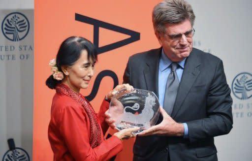 Aung San Suu Kyi receives the Asia Society's Global Vision Award from Tom Freston, trustee, at the United States Institute of Peace in Washington, DC. At the award ceremony, Suu Kyi took pains to reassure China over her trip to the US, which was the junta's main ally