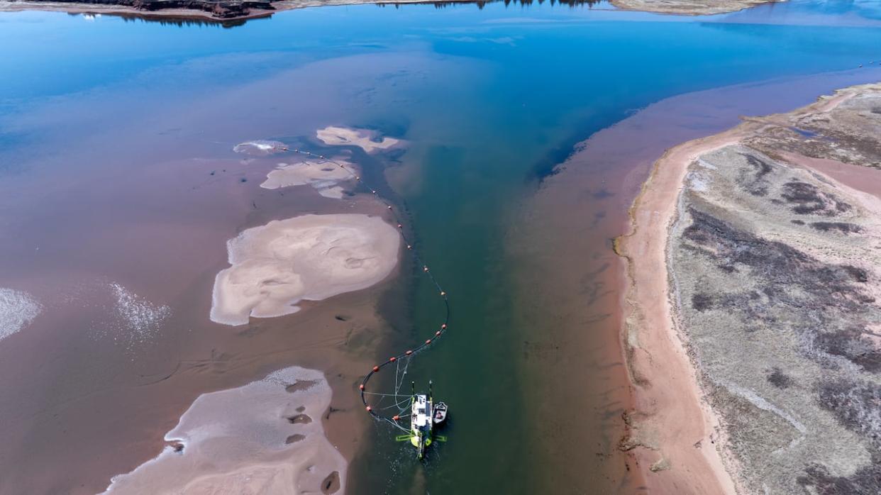 A dredge at work trying to clear the sand in the channel leading to Malpeque Harbour.  (Shane Hennessey/CBC  - image credit)