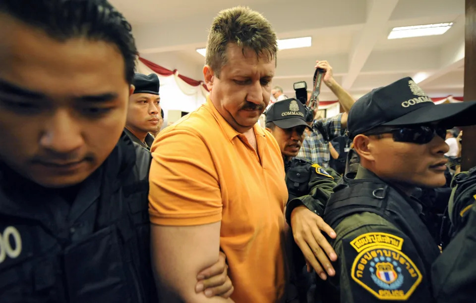 Thai commandos escort back hand-cuffed Russian arms dealer Viktor Bout (C), known as the 