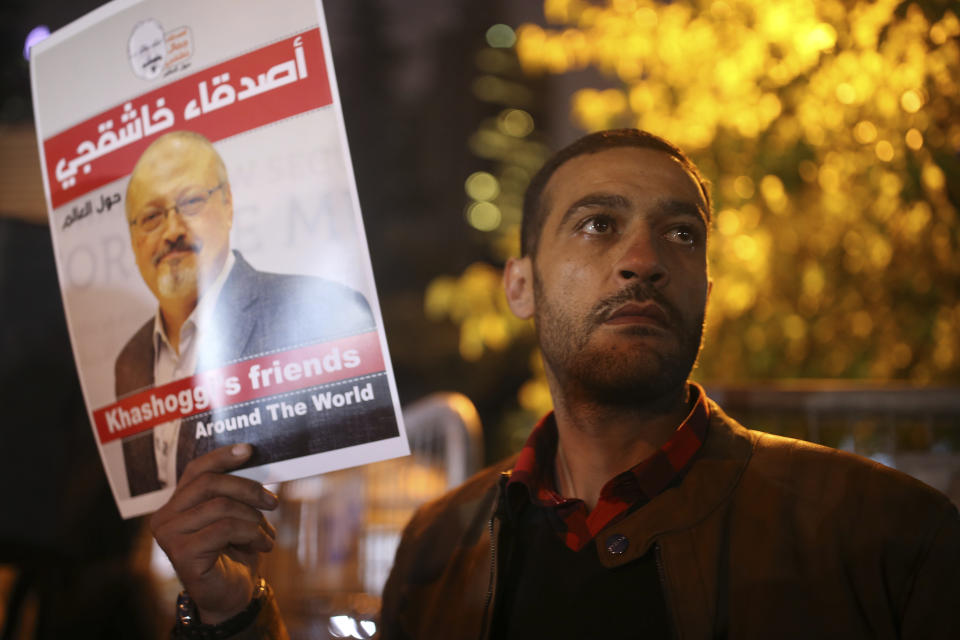 Activists, protesting the killing of Saudi journalist Jamal Khashoggi, hold a candlelight vigil outside Saudi Arabia's consulate in Istanbul, Thursday, Oct. 25, 2018. The poster reads in Arabic:' Khashoggi's Friends Around the World'. A group of Arab and international public, political and media figures are establishing a global association called "Khashoggi's Friends Around the World"; "to achieve justice for the freedom martyr".(AP Photo/Emrah Gurel)