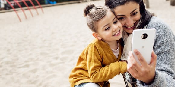 A woman and a child take a selfie with a Windows Phone.