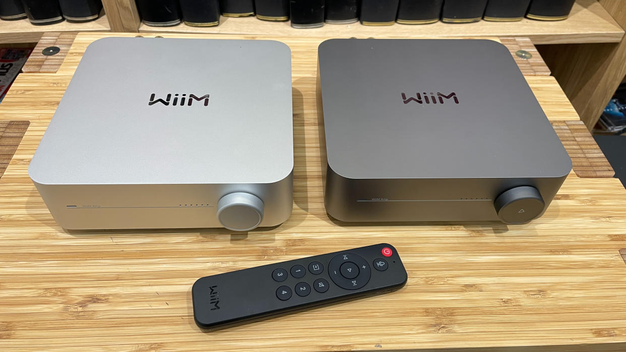  Two WiiM Amp products showing two different finishes and remote control. 