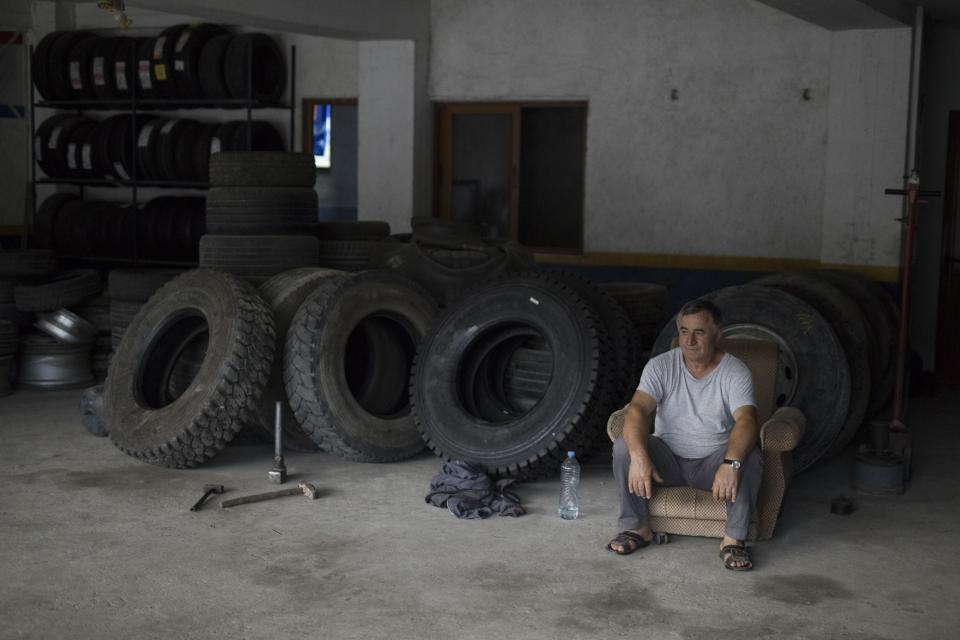 Ahmet Alimerkaj espera la llegada de clientes en su negocio de Ballsh. (AP Photo/Daniel Cole)