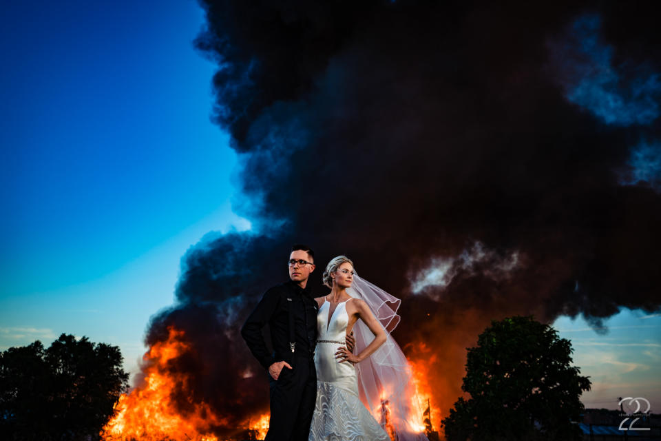 Dillon and Corrie Jameson pose against an abandoned building going up in flames. (Photo: Studio 22 Photography, Destination Wedding and Engagement Photographer)