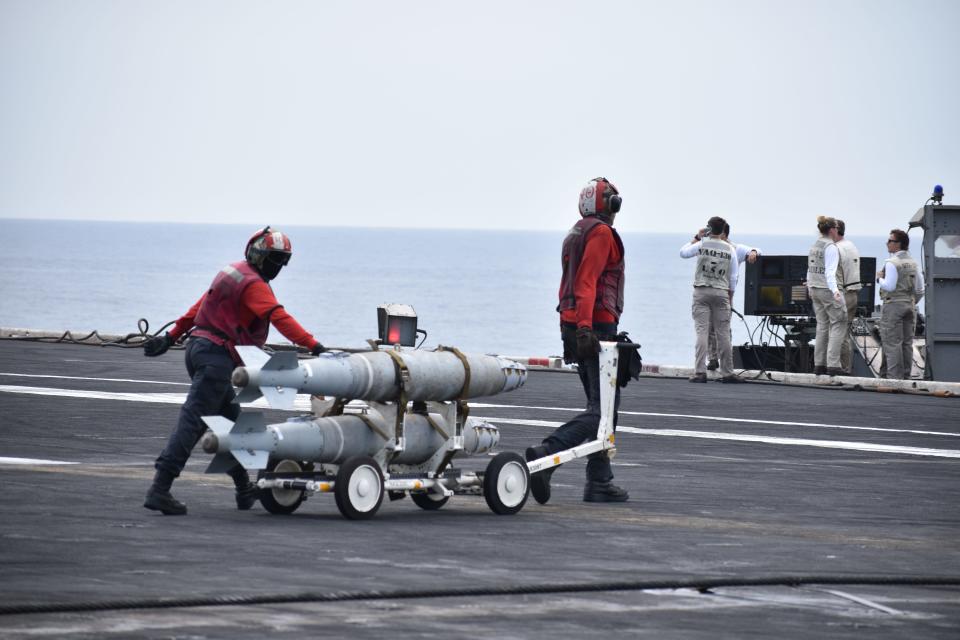 Sailors transport munitions on the deck of the USS Dwight D. Eisenhower.