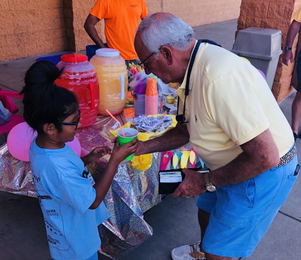 Hope Campos, left, sells one of her first cups of lemonade to former United Family CEO Robert Taylor during a Lemonade Day kick-off event Saturday at Amigos supermarket.