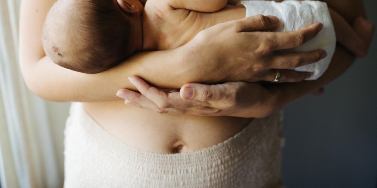 pelvis of woman in postpartum diaper holding baby postpartum pelvic health