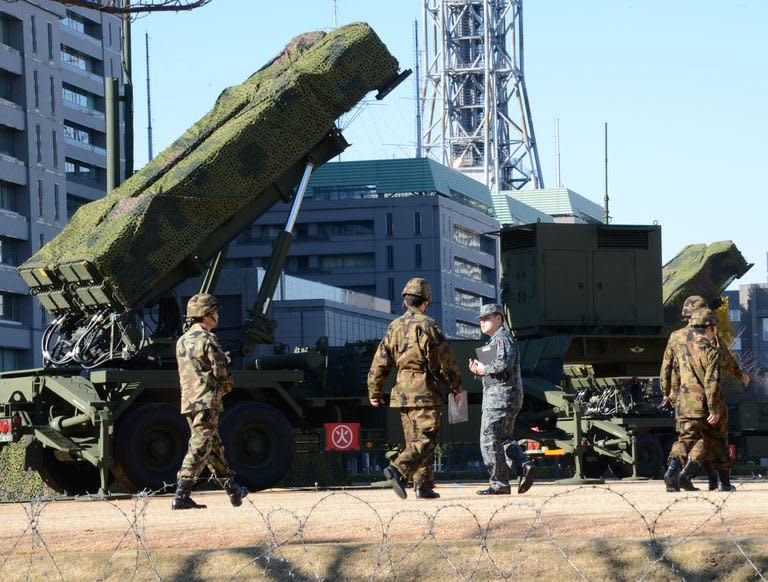 Officers of the Ground Self-Defense Force (SDF) walk in front of a Patriot Advanced Capability-3 (PAC-3) missile launcher at the Defence Ministry in Tokyo on December 6, 2012