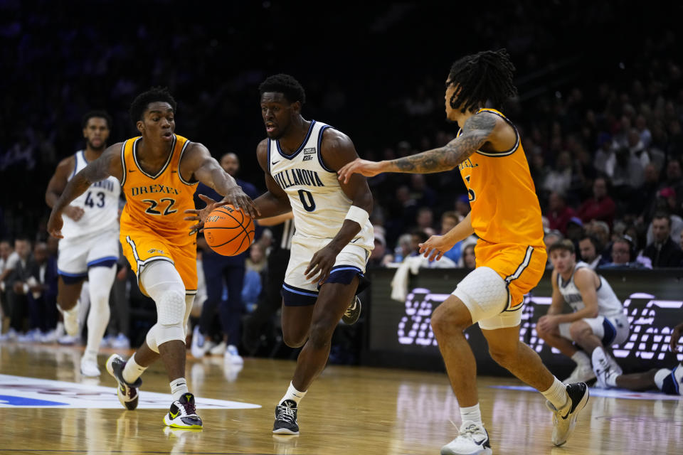 Villanova's TJ Bamba (0) tries to get past Drexel's Amari Williams (22) and Kobe MaGee, right, during the half of an NCAA college basketball game, Saturday, Dec. 2, 2023, in Philadelphia. (AP Photo/Matt Rourke)