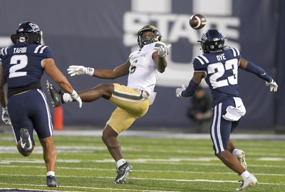 Colorado State wide receiver Dylan Goffney (6) reaches for the ball as Utah State linebacker MJ Tafisi Jr. (2) and safety Devin Dye defend during the first half of an NCAA college football game Saturday, Oct. 7, 2023, in Logan, Utah. | Eli Lucero/The Herald Journal via AP