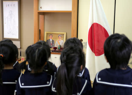 FILE PHOTO - Students recite the Imperial Rescript on Education and Confucian Analects in front of JapanÕs national flag, a picture of Japanese Emperor Akihito and Empress Michiko, and a hanging scroll of Confucius at Tsukamoto kindergarten in Osaka, Japan, November 30, 2016. REUTERS/Ha Kwiyeon/File Photo