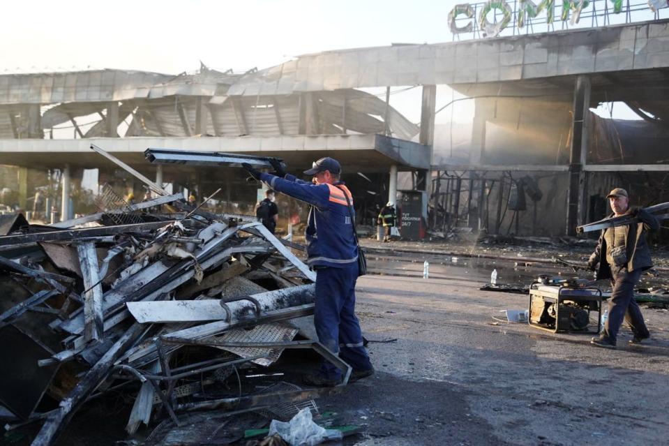 Emergency service workers clear the rubble following a Russian missile strike on a shopping mall, where both the Silpo and Comfy retail chains had stores, in Kremenchuk, Poltava Oblast on June 27, 2022. The attack killed at least 21 people and inured more than 50. (Comfy/ UNIAN)