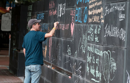 Russ Naranjo of Charlottesville writes a message about the "Unite the Right" rally on the city's "Free Speech Wall" along the downtown mall in Charlottesville, Virginia, August 14, 2017. REUTERS/Justin Ide