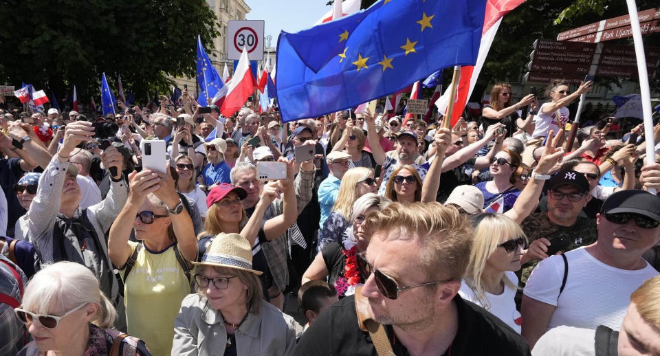 Una multitud avanza en una marcha antigubernamental encabezada por el dirigente opositor Donald Tusk, quien junto con otros críticos acusa al gobierno de socavar la democracia, el domingo 4 de junio de 2023, en Varsovia. (AP Foto/Czarek Sokolowski)