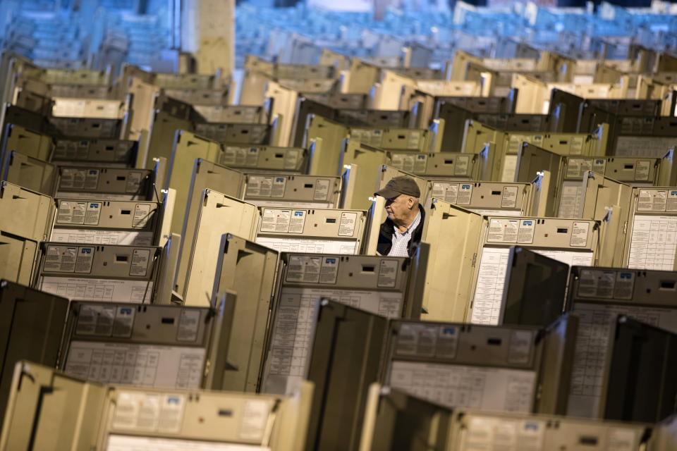 FILE- In this Oct. 14, 2016, file photo, a technician works to prepare voting machines to be used in the presidential election, in Philadelphia. The FBI, in a change of policy, is committing to inform state officials if local election systems have been breached, federal officials told The Associated Press. (AP Photo/Matt Rourke, File)