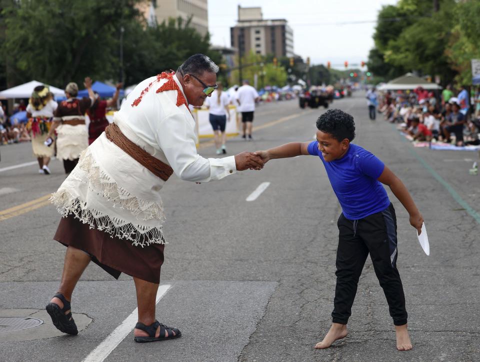 Carl Makaafi, right, shakes hands with a member of the Salt Lake Utah (Tongan) West Stake during the Days of ’47 Parade in Salt Lake City on Monday, July 24, 2023. | Laura Seitz, Deseret News