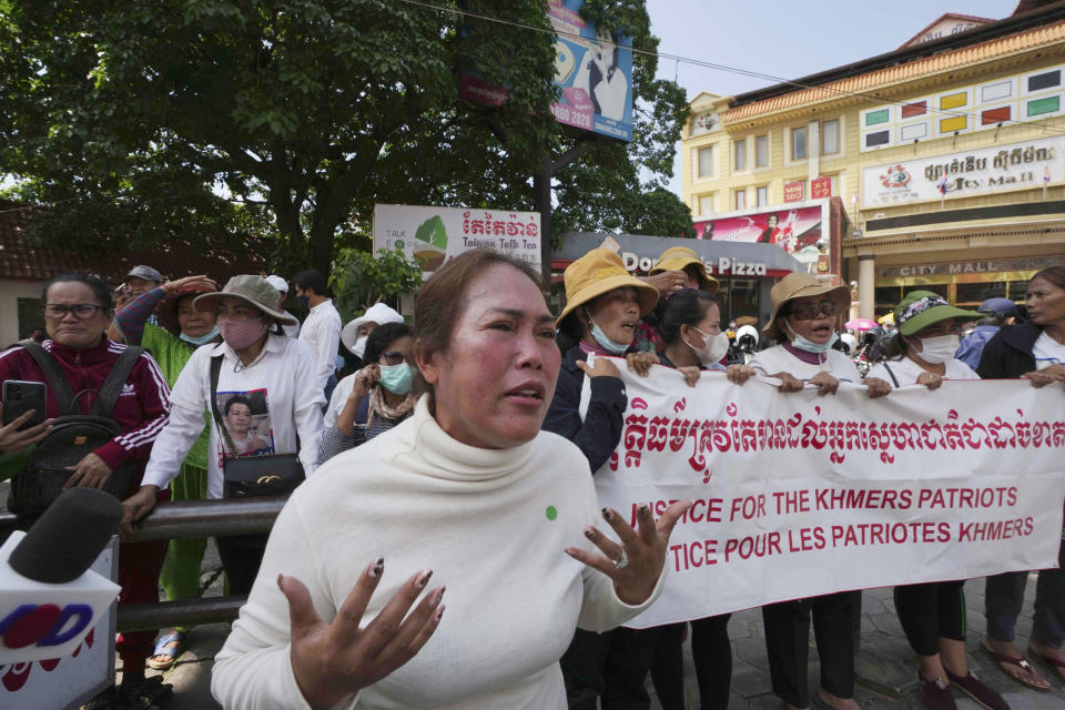 Supporters of the former Cambodia National Rescue Party and wives of convicted people of treason and related charges hold a rally in front of the the Phnom Penh Municipal Court in Phnom Penh, Cambodia, Tuesday, June 14, 2022. A Cambodian American lawyer and dozens of members of the now-dissolved opposition party were convicted of treason Tuesday in a trial that was the latest move to tame all opposition to the long-running rule of Prime Minister Hun Sen. (AP Photo/Heng Sinith)