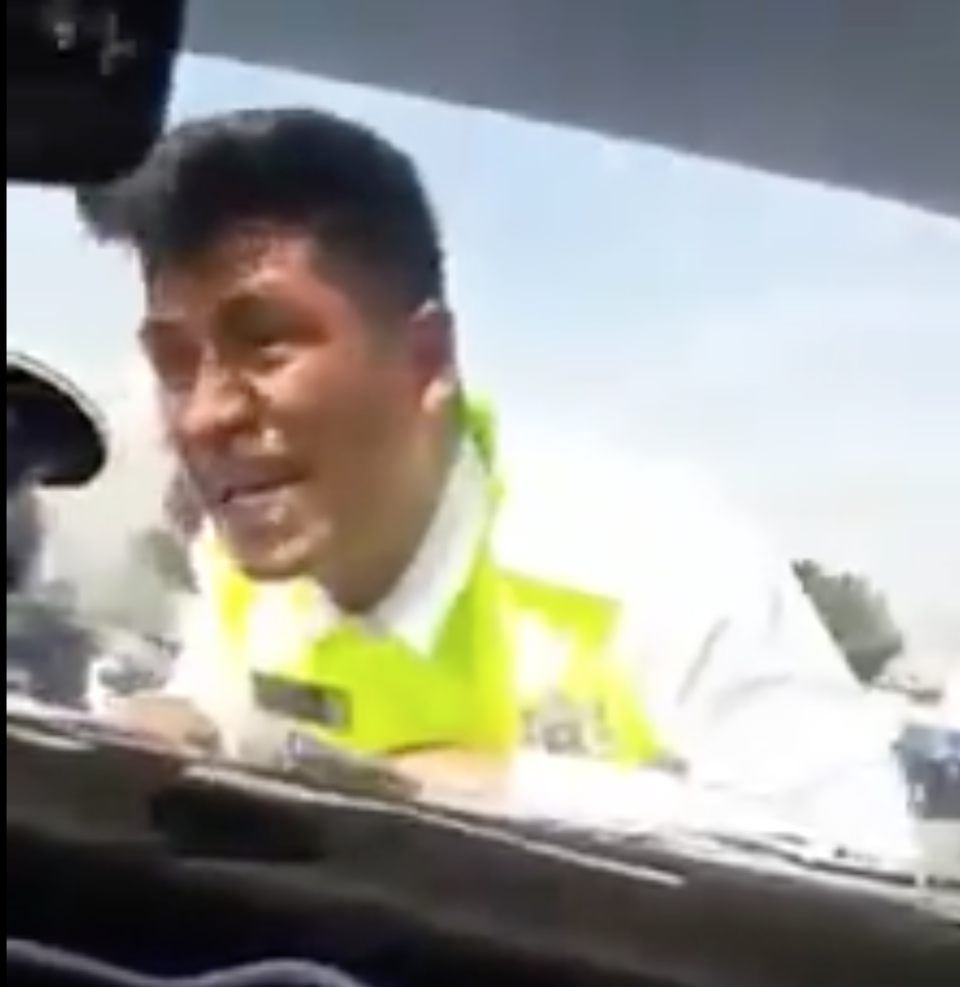 El agente, Humberto Torres, mientras el conductor le traslada a gran velocidad. (Azteca Noticias).