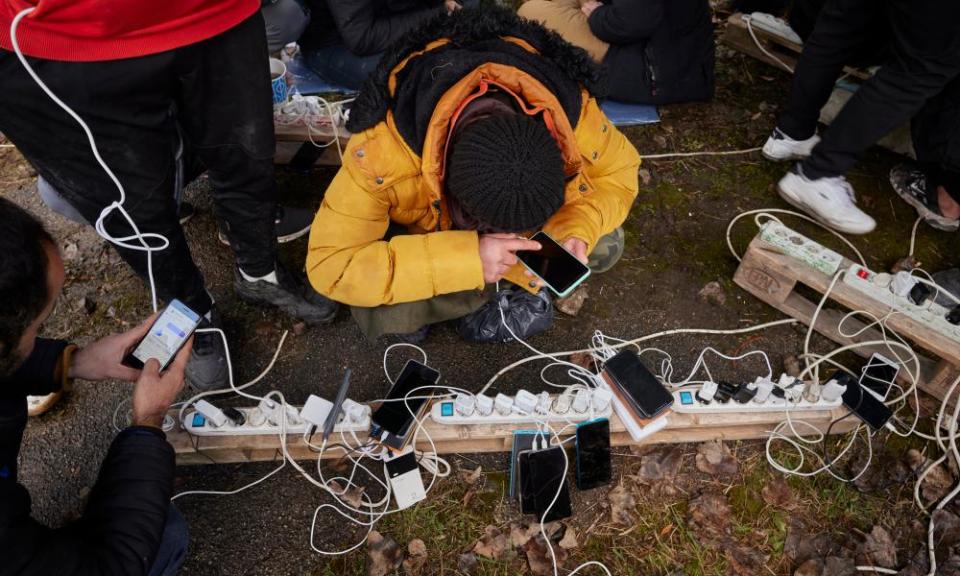 People charge phones outdoors