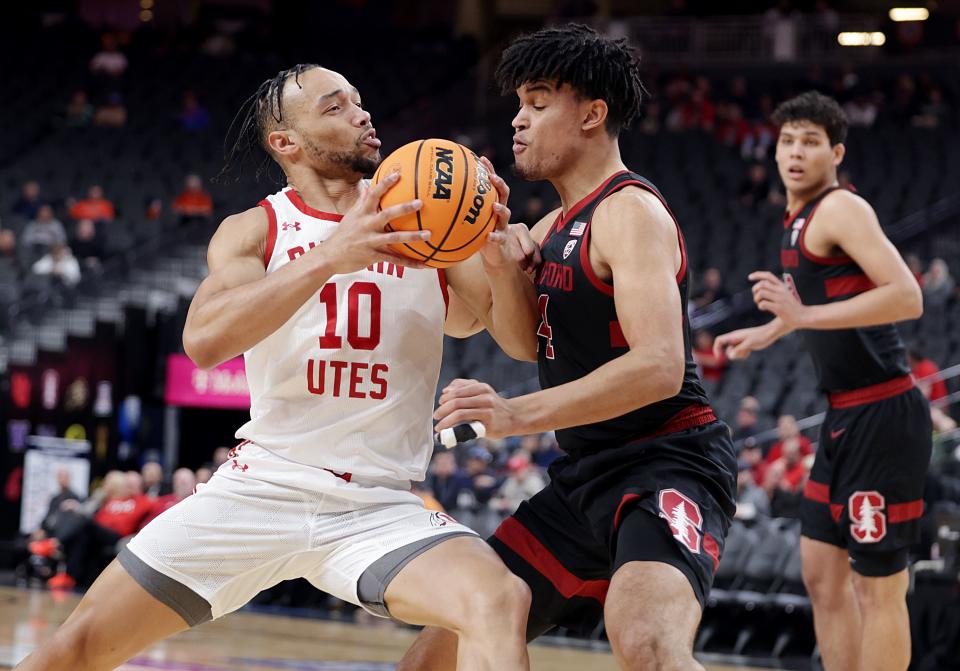 Utah guard Marco Anthony drives on Stanford forward Spencer Jones in Pac-12 tournament action at T-Mobile Arena.