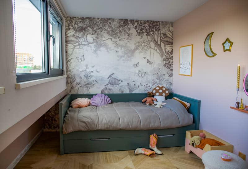 Daybed hugs walls in child's pastel bedroom.