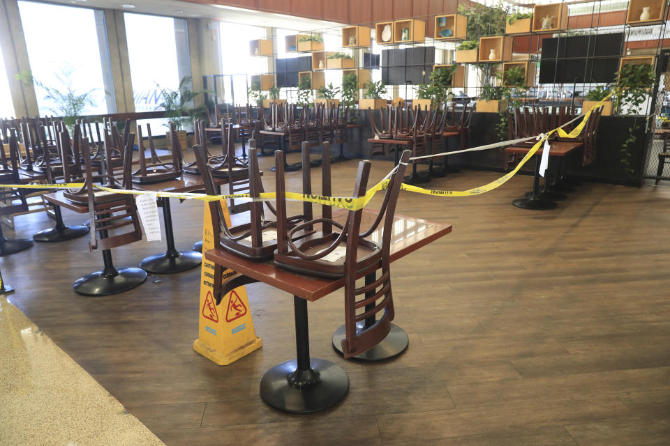 A restaurant remains closed inside the Daniel K. Inouye International Airport Thursday, Oct. 15, 2020, in Honolulu. The COVID-19 pandemic has caused a devastating downturn on Hawaii's tourism-based economy. Many stores and restaurants inside the airport remain close due the the economic crisis. (AP Photo/Marco Garcia)